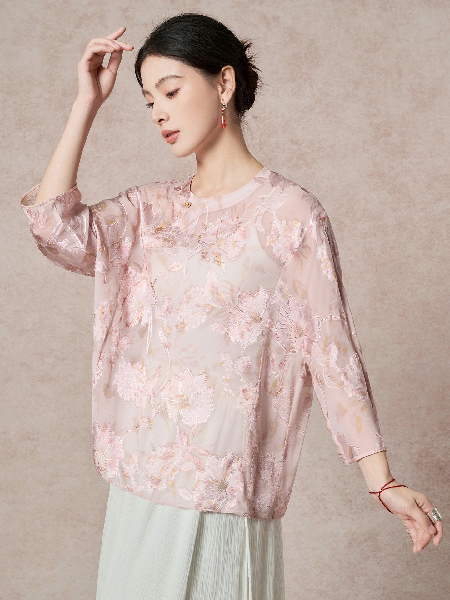 Front view of a women's pink sheer silk blouse with intricate floral cutwork and a relaxed fit, showcasing the lightweight and breathable 100% Mulberry Silk fabric.