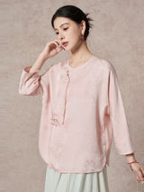 Side view of a pink silk blouse with a relaxed fit and a flowing drape, highlighting the elegant texture of the jacquard fabric.