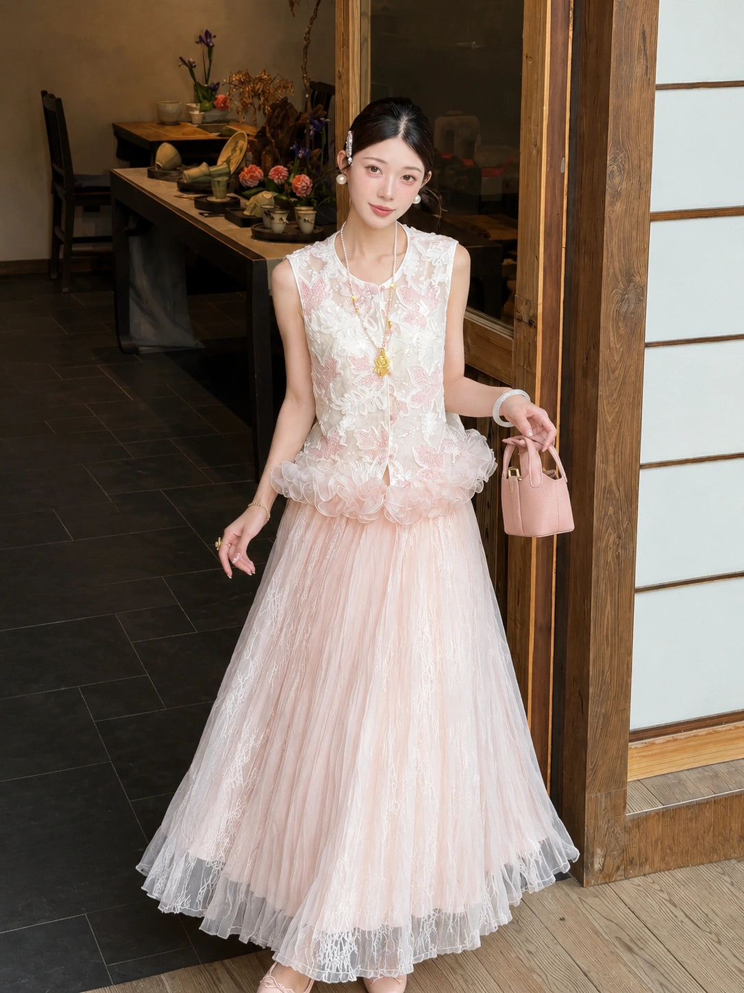 Side view of a pink pleated tulle skirt with lace panels, paired with an embroidered top, showcasing the flowy and romantic silhouette.