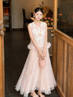 Full body shot of a pink pleated tulle skirt with lace overlay, styled with a white embroidered top and pink handbag, perfect for a romantic New Chinese look.