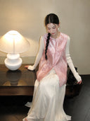 Model wearing a pink Zhangduan silk Chinese vest with a round neckline and bamboo, plum, and peach floral motifs.