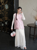 Full-body styling of a medium-length pink Zhangduan silk vest paired with a flowing white dress.