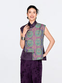 Front view of a woman wearing the purple mulberry silk vest with turquoise, blue and gold Shu brocade medallions.