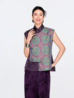 Front view of a woman wearing the purple mulberry silk vest with turquoise, blue and gold Shu brocade medallions.