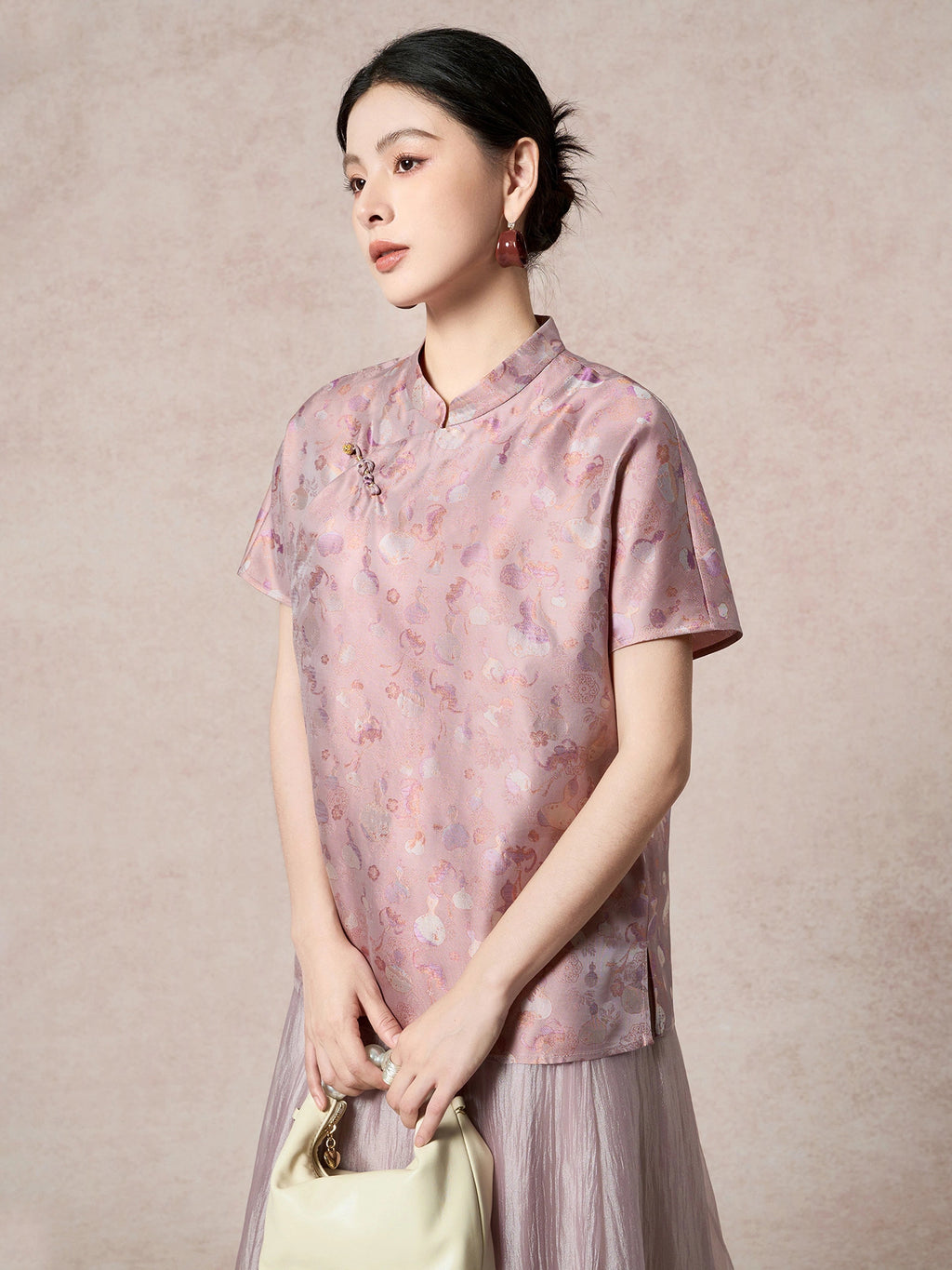 Model wearing a purple silk Cheongsam top with a relaxed fit, holding a cream handbag, showcasing the elegant drape and lustrous sheen.