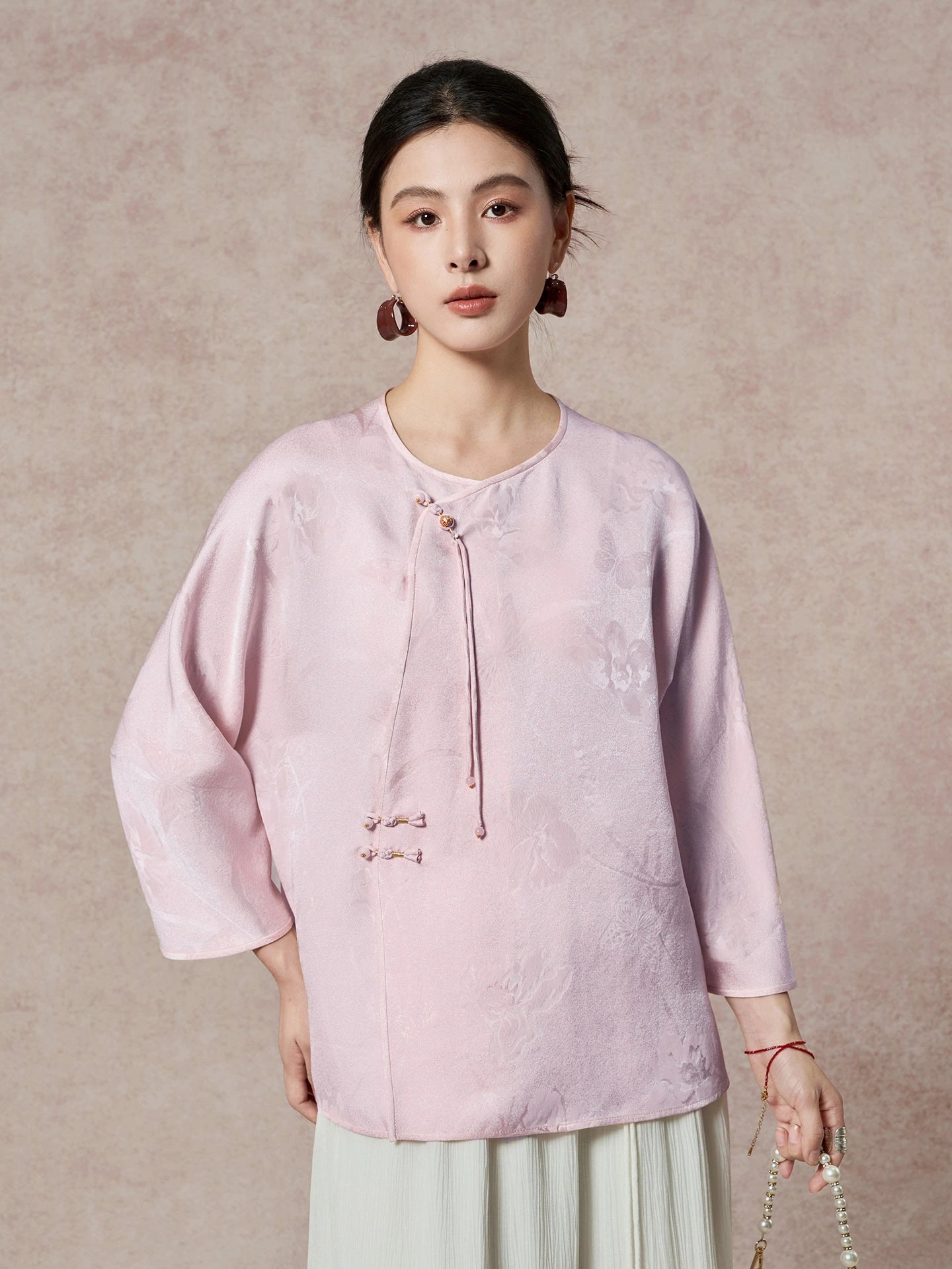Front view of a purple silk blouse with an asymmetrical closure, showcasing the loose, comfortable silhouette and soft sheen.