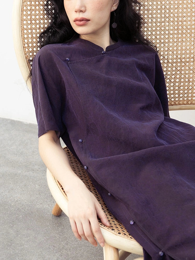 Close-up of the Mandarin collar, asymmetrical placket and fabric-covered buttons on a purple silk qipao dress.