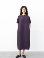 Front view of a model wearing a purple 100% mulberry silk modern qipao dress with short sleeves and side pockets.