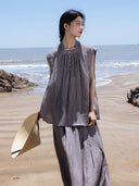 Woman wearing a grey ramie lyocell sleeveless top and maxi skirt two-piece set at the beach.