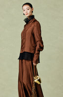Three-quarter view showing the shirt’s relaxed sleeves, buttoned front and subtle tonal texture.