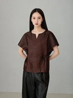 Close-up of red Xiangyunsha mulberry silk top showing refined neckline detail and soft natural silk texture.