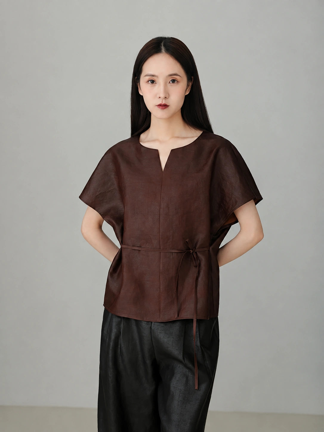 Close-up of red Xiangyunsha mulberry silk top showing refined neckline detail and soft natural silk texture.