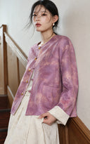 Model by a staircase wearing the purple floral jacket with a cream skirt.