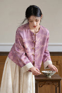 Model wearing the purple jacquard jacket with ivory cuffs turned up and a cream skirt.