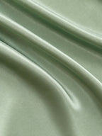 Close-up of the smooth sage green acetate and mulberry silk blend fabric