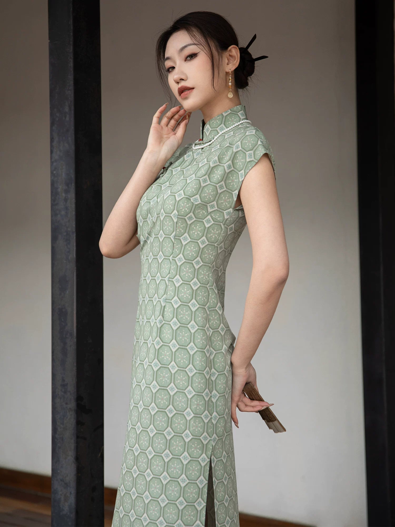 Side view of the sage green jacquard cheongsam dress showing the fitted silhouette and woven texture.