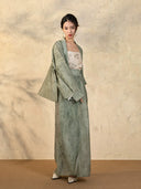 Side view showcasing the relaxed draped sleeve jacket and wrap skirt silhouette.