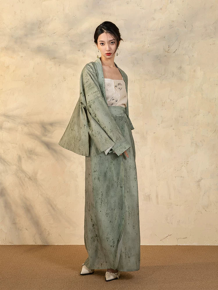 Side view showcasing the relaxed draped sleeve jacket and wrap skirt silhouette.