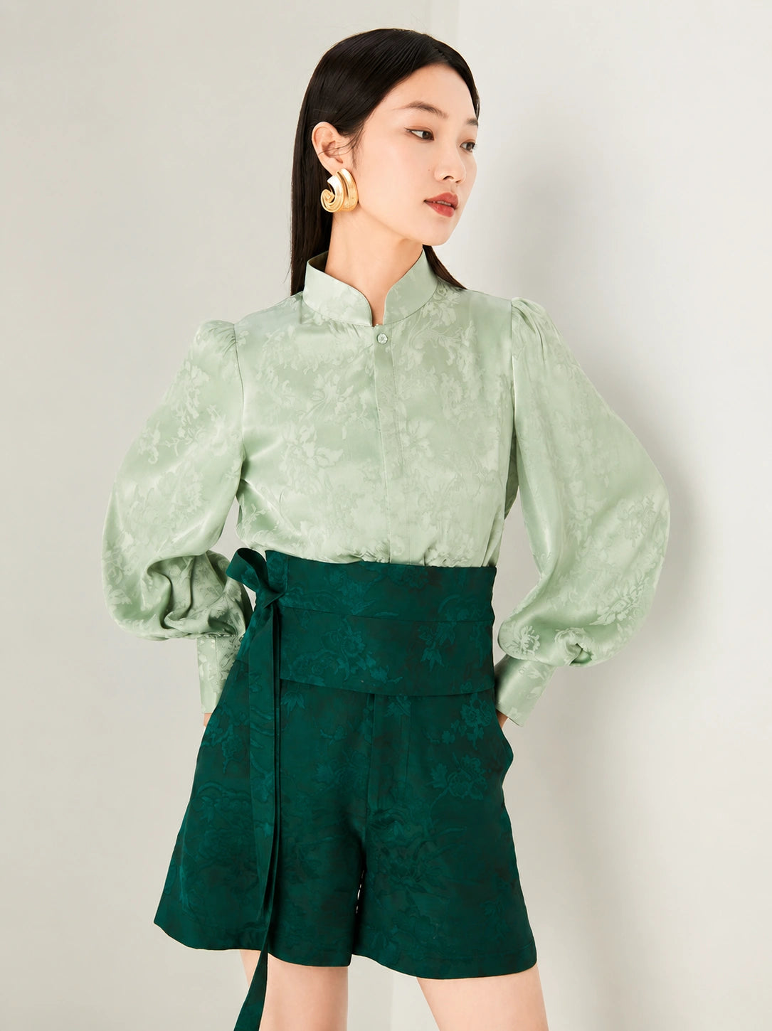 Close-up of the sage green jacquard blouse with stand collar.