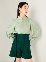 Close-up of the sage green jacquard blouse with stand collar.