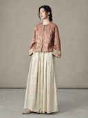 Model wearing the peach jacquard jacket with a long cream skirt