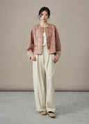 Model wearing the jacket open over a cream outfit, front view