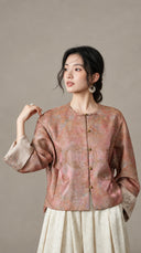 Model wearing the buttoned peach jacket with one embroidered cuff visible