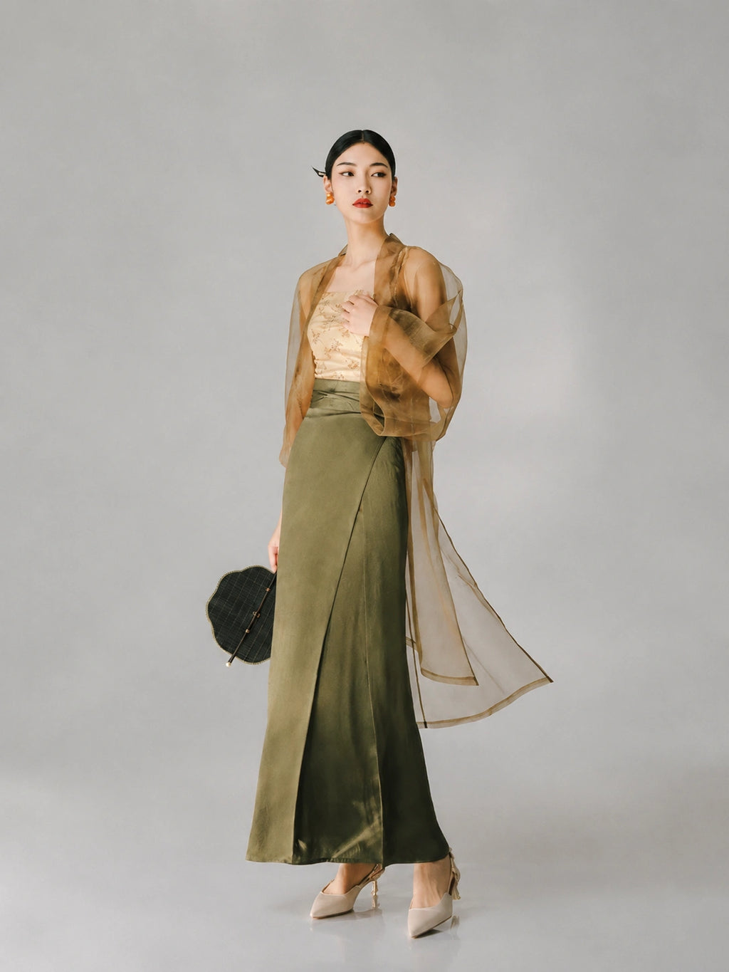 Woman wearing a sheer tea brown organza long cover-up over an elegant dress.