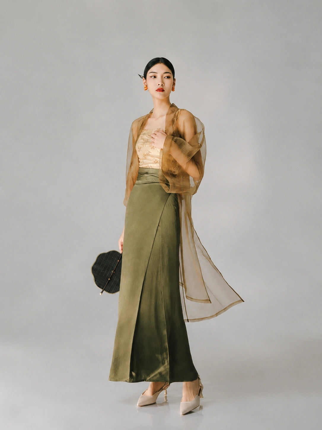 Woman wearing a sheer tea brown organza long cover-up over an elegant dress.