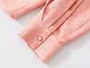 Close-up of the pink jacquard sleeve and buttoned cuff.