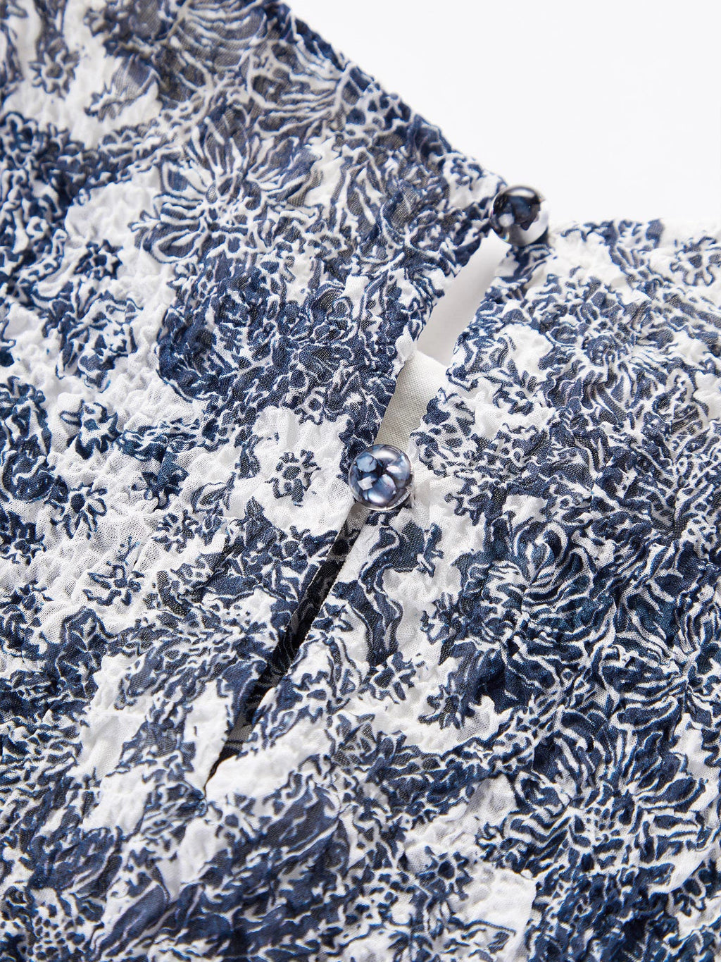 Close-up detail of the textured bubble crepe silk fabric and back button closure, showcasing the intricate print and premium quality of the 96.2% Mulberry Silk.
