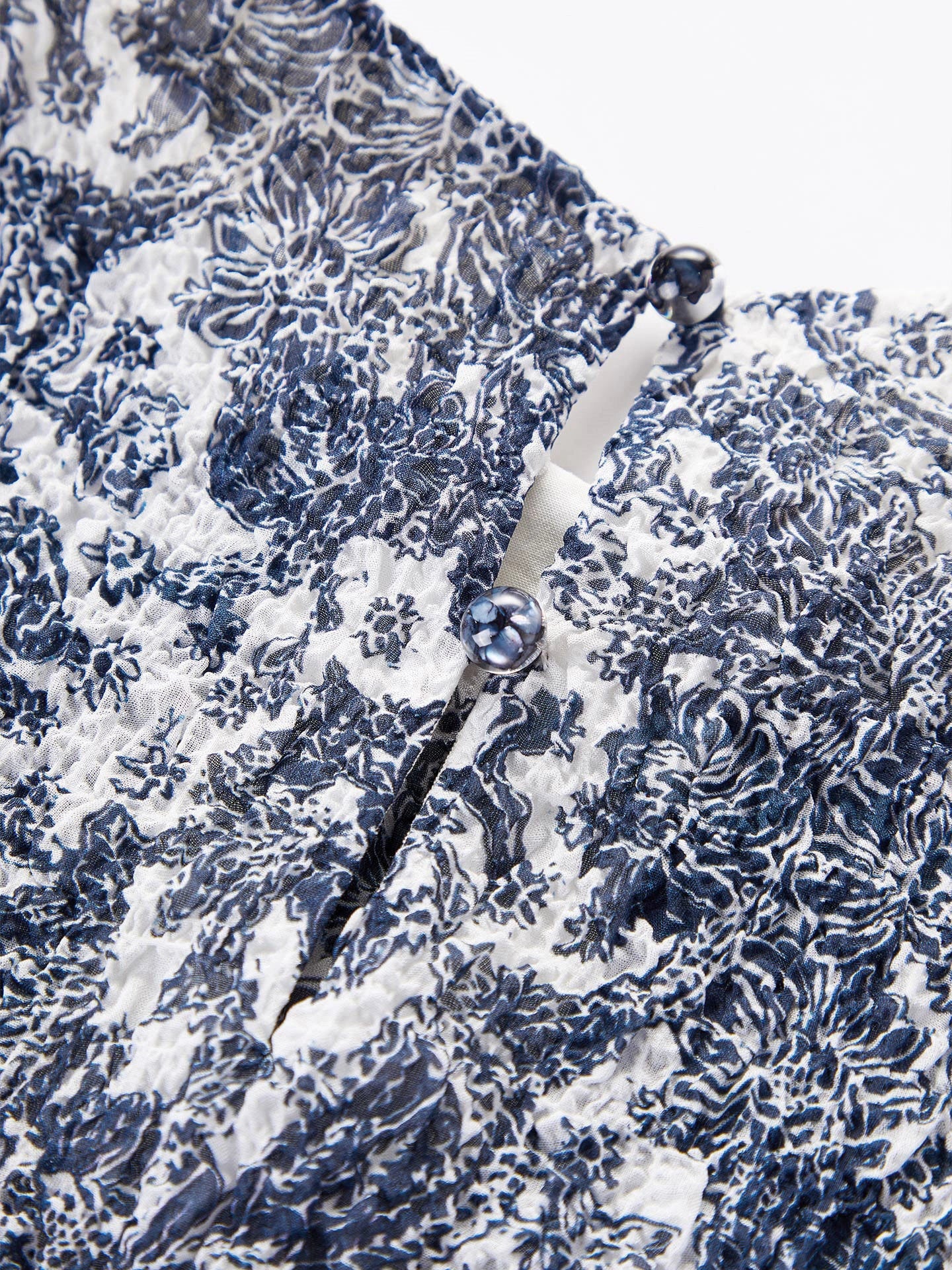 Close-up detail of the textured bubble crepe silk fabric and back button closure, showcasing the intricate print and premium quality of the 96.2% Mulberry Silk.