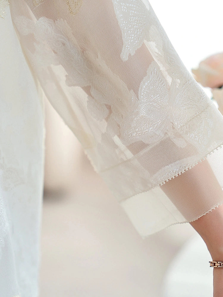 Close-up of a white sheer silk chiffon sleeve featuring delicate cutwork embroidery and a scalloped hem, showcasing the lightweight and intricate craftsmanship.