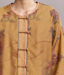 Close-up of the jacket’s round neckline, button front, embroidered deer and flowers