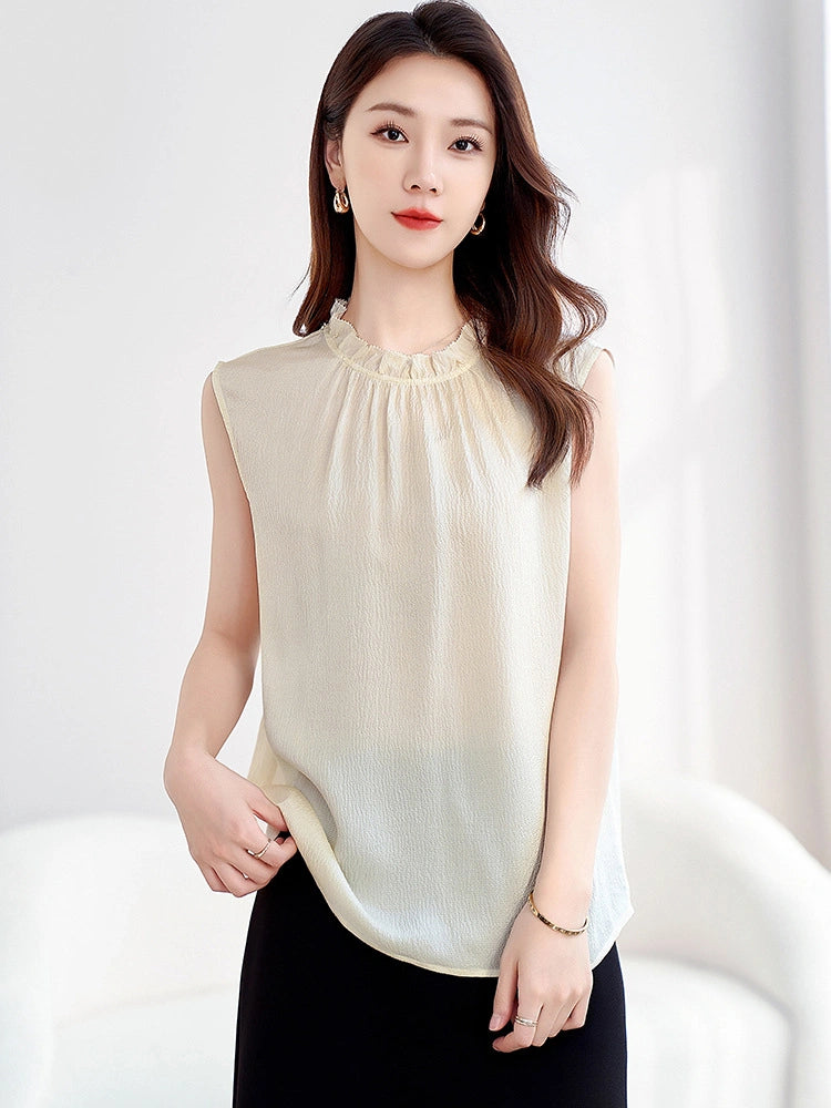 Close-up of a cream beige silk top with a ruffled neckline and bubble crepe texture, showcasing the lightweight and breathable fabric.