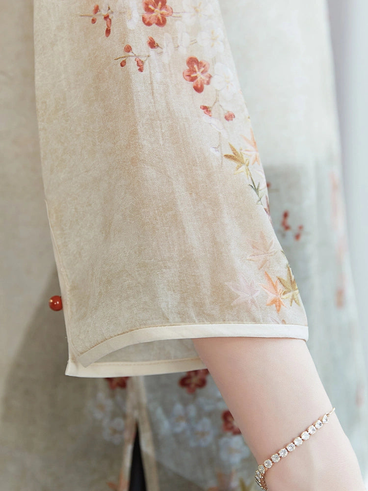 Close-up of the sleeve detailing on a beige 100% mulberry silk shirt, featuring delicate red and orange floral prints with a white piped hem.