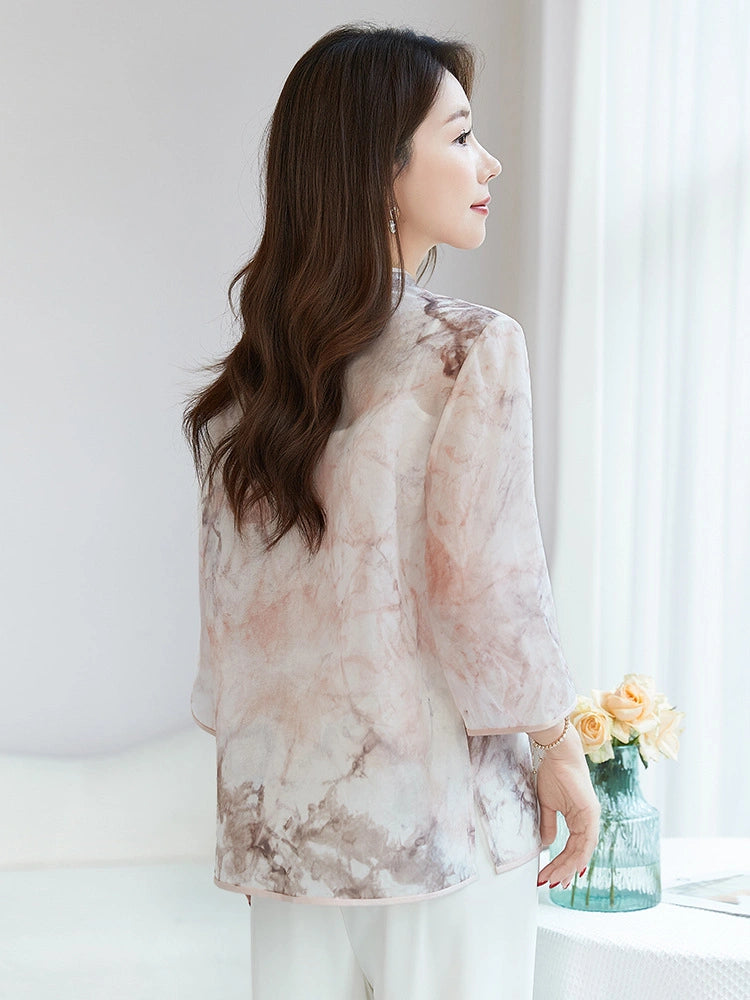 Back view of a women's 100% silk blouse with a relaxed fit and a soft, flowing drape, highlighting the elegant watercolor print.