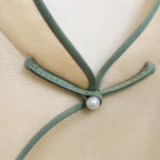 Close-up of the Mandarin collar, sage green piping and pearl-style frog button on the silk vest