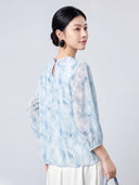 Back view of the sky blue mulberry silk blouse with a round neck and keyhole button closure