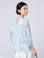 Back view of the sky blue mulberry silk blouse with a round neck and keyhole button closure