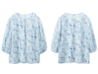 Front and back product view of a sky blue printed silk blouse with three-quarter sleeves