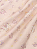 Close-up of the pale blush fabric with floral bursts and small animal motifs