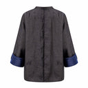 Back view of the model wearing the dark jacquard jacket with a blue turned-back cuff
