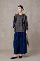 Full-length styling view of the buttoned jacket with blue wide-leg trousers