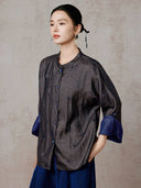 Angled view of the relaxed silk jacket showing its mandarin collar and tonal pattern