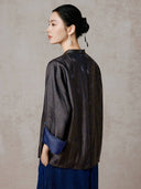 Back view of the model wearing the dark jacquard jacket with a blue turned-back cuff