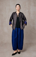 Full-length front view of the open jacket with blue cuffs and wide-leg trousers