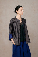 Side styling view of the open silk jacket over a black top