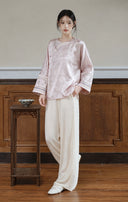 Full-length front view of the smoky pink asymmetric-front jacket styled with ivory wide-leg trousers.