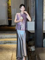 Model wearing a smoky purple satin maxi skirt paired with a purple embroidered vest, holding a decorative fan, highlighting the versatile styling.